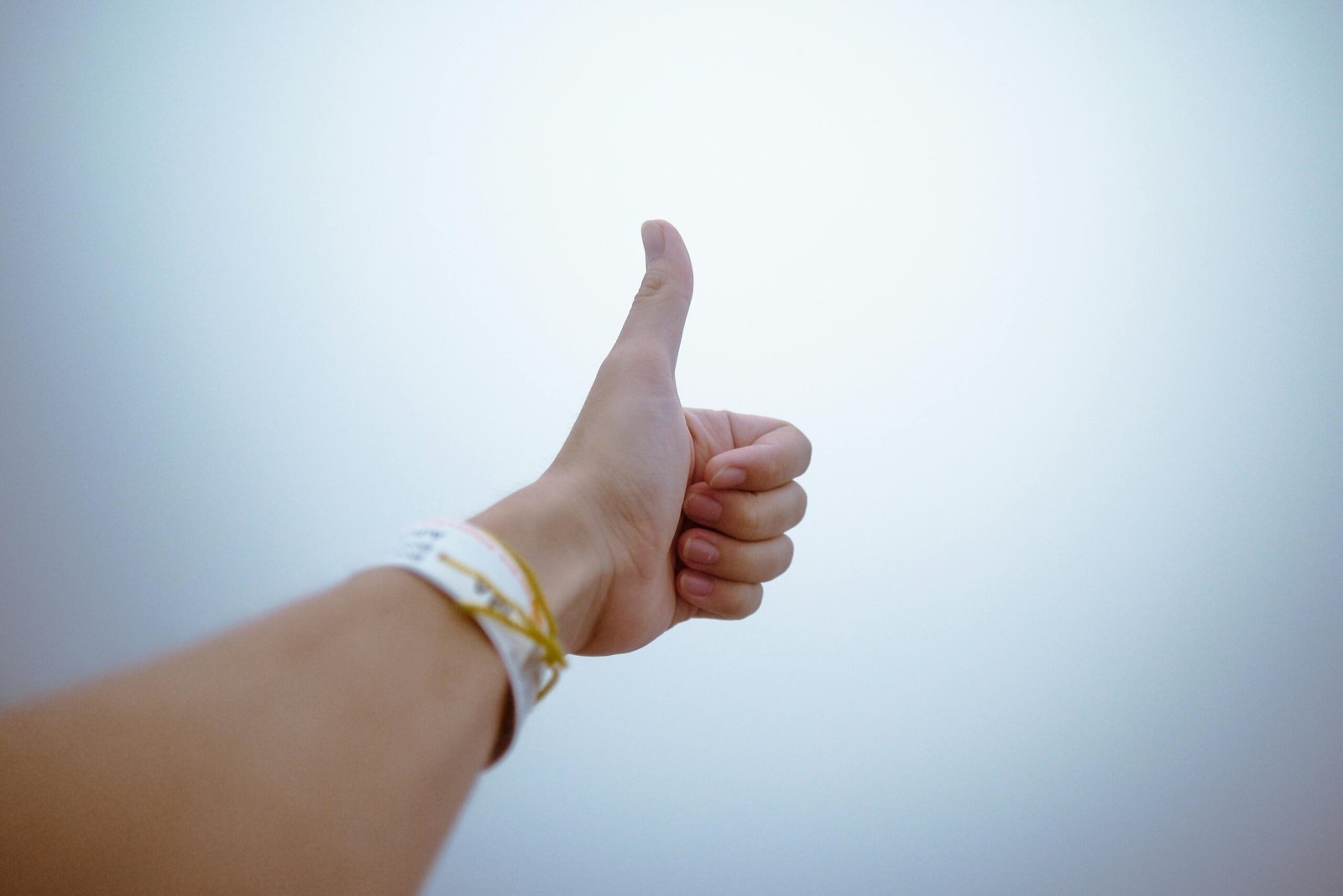 Home A hand giving a thumbs up gesture symbolizes approval and positivity.